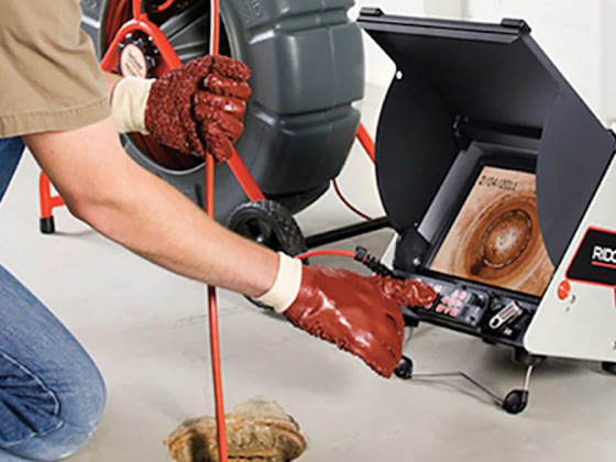 Technician monitors pipe using inspection camera