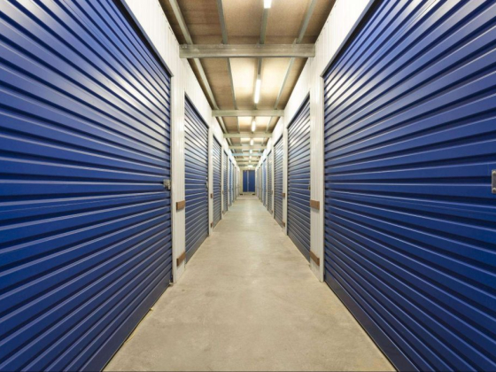 A hallway with locked blue storage unit doors
