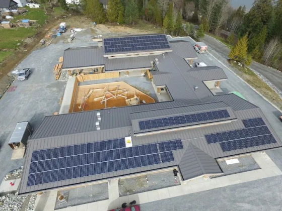 Building with solar panels surrounded by trees
