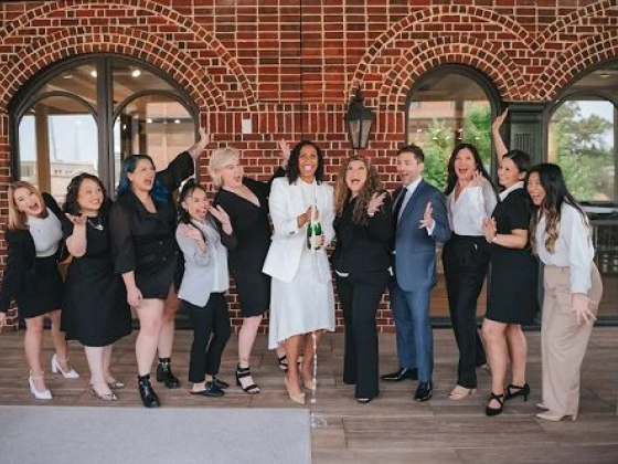 People cheerfully posing with champagne bottles