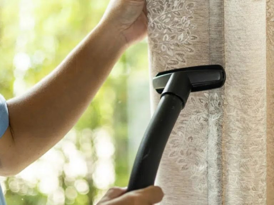 Vacuum cleaner used on ornate curtain