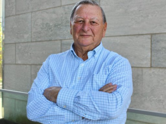 Elderly man standing confidently with folded arms