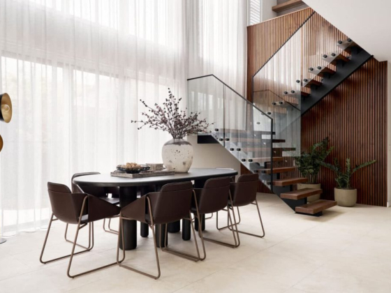 Sleek dining room design with glass railing staircase