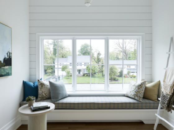 Window seat with cushions overlooking a suburban street