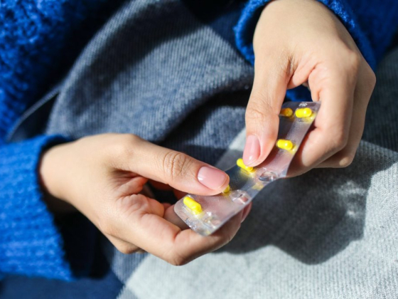 Person holding blister pack with yellow pills