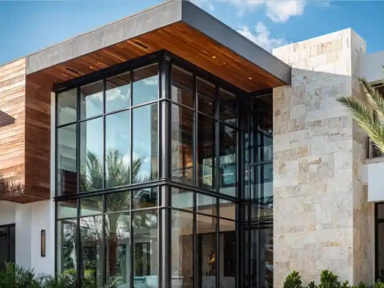 Contemporary home with glass facade and stone accents