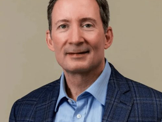 Man wearing blue suit and shirt against neutral background