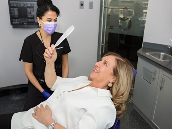 Dentist assists patient during dental examination