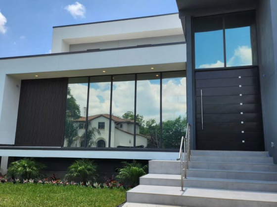 Contemporary house exterior with large glass windows and steps leading to entrance