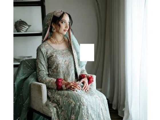 Bride gazing out while sitting elegantly in traditional dress