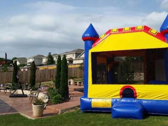 Bright inflatable castle on a lawn next to a patio