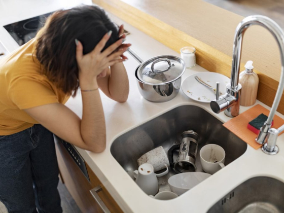 A person overwhelmed by kitchen cleaning tasks