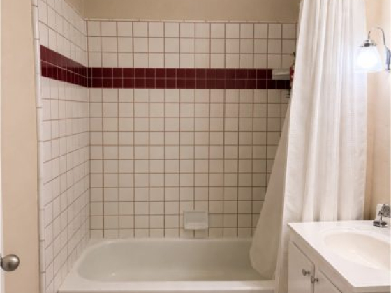 Clean bathroom featuring bathtub and sink area