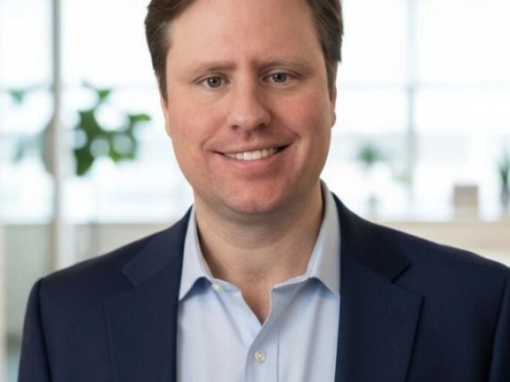 Smiling man in a blue suit inside a modern office setting