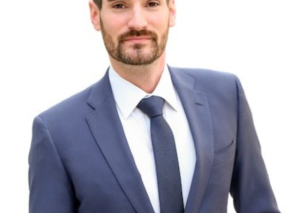 Confident man in a blue suit poses professionally