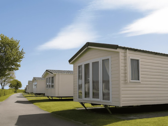 Mobile homes lined along a pathway with blue sky above