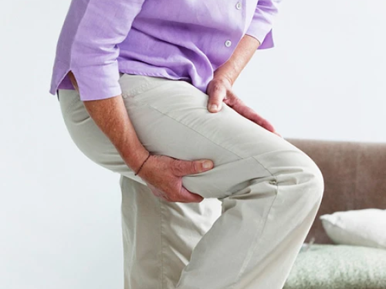 Individual experiencing leg discomfort indoors