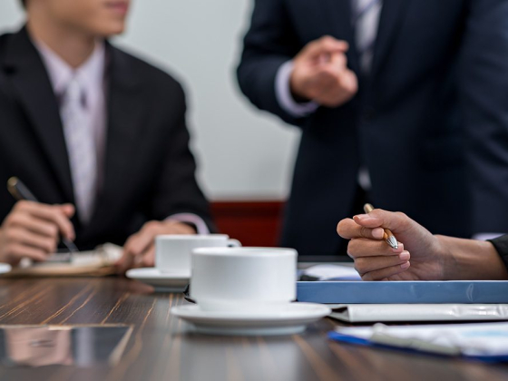 Professionals in suits discussing around a table