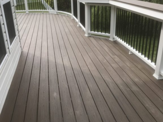 A wooden deck with a small red can on the railing