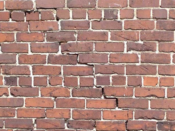 Close-up of a brick wall showing prominent cracks