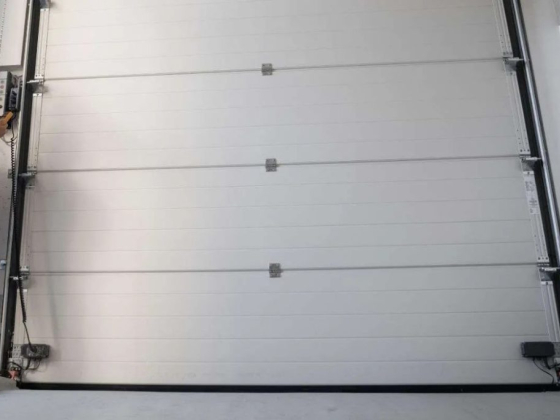Technician controls a white garage door mechanism