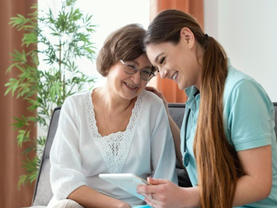 Smiling nurse shares information with elderly woman