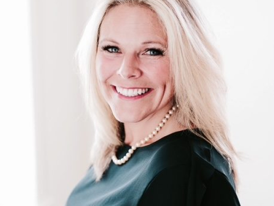 Woman in black attire with a cheerful expression