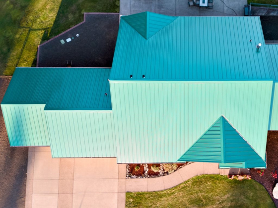 Geometric teal metal roof from above with garden and pathway