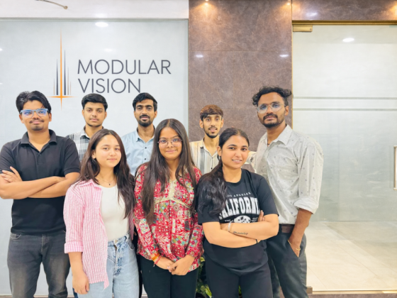 Team photo in front of Modular Vision logo