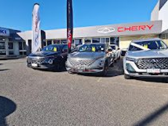 Three cars parked outside a Chery dealership