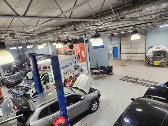 Several cars being serviced in a spacious garage workshop