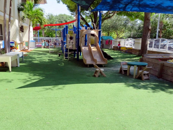 Outdoor playground with slides and tables under shade