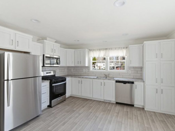 Spacious kitchen featuring new appliances and bright cabinets
