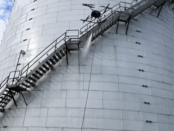 Aerial drone performs maintenance on industrial tank