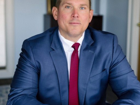 Professional man seated at a white table in office setting