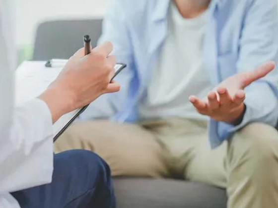 Counselor taking notes while listening to a client