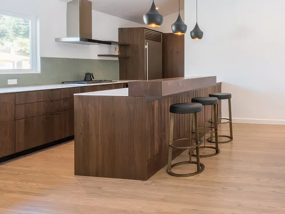 Sleek kitchen featuring a wooden island and hanging lights