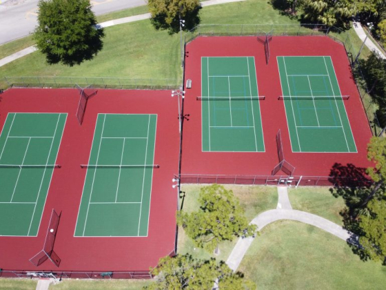 Overhead shot of red and green tennis courts.