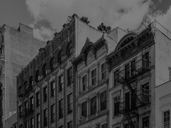 Row of ornate vintage buildings against cloudy sky