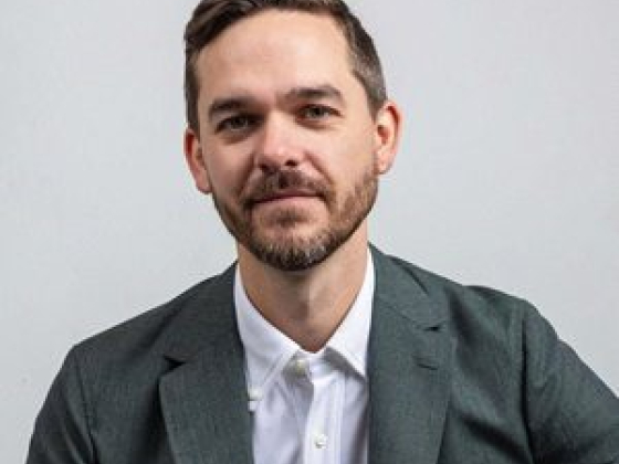Bearded man in suit against plain background