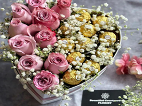 Pink roses and chocolates in a heart-shaped gift box