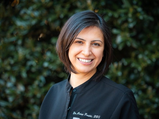 Portrait of a smiling woman against leafy background