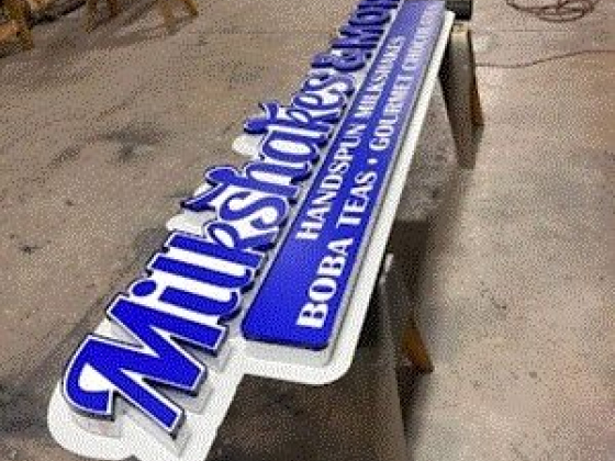 Long shop sign with bold text in a workshop setting