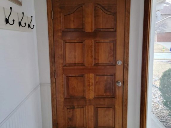 Entryway with wooden door and coat hooks