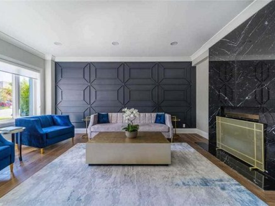Elegant room boasting blue chairs and black marble fireplace
