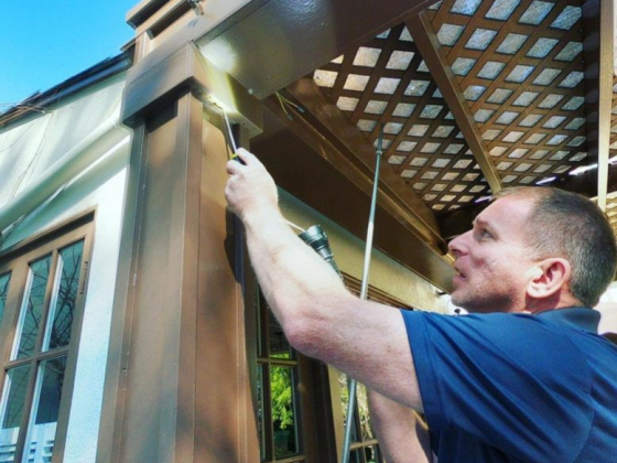 Man examining building exterior corner