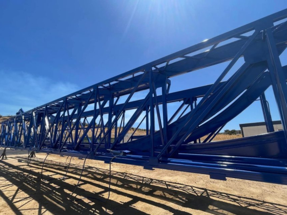 Aerial view of blue metal structure in sunny landscape