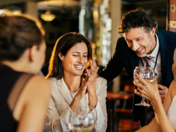 Friends sharing laughter and drinks in a lively bar setting