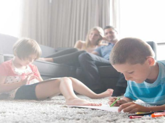 Kids drawing while parents relax on sofa