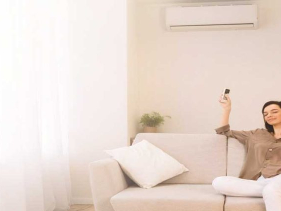 Woman comfortably using AC remote on sofa
